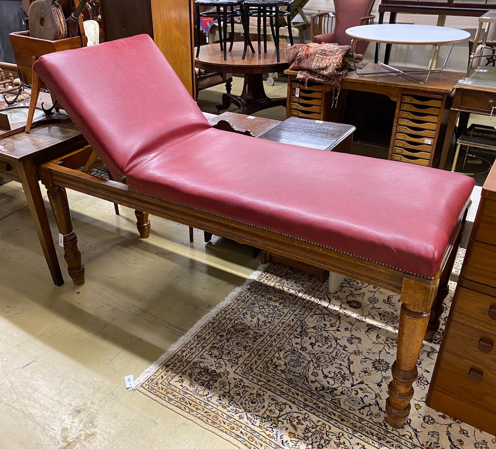 An Edwardian mahogany examination table by Ferris & Co. with red leatherette upholstery, length 186cm, height 63cm